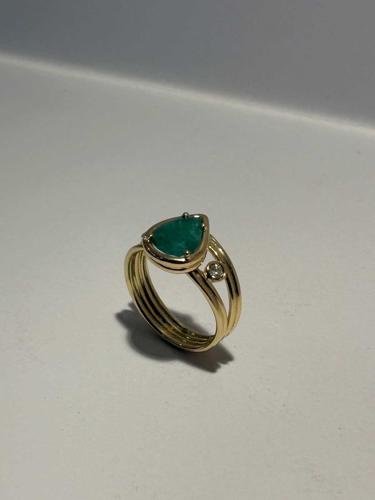 Anel dourado com pedra verde