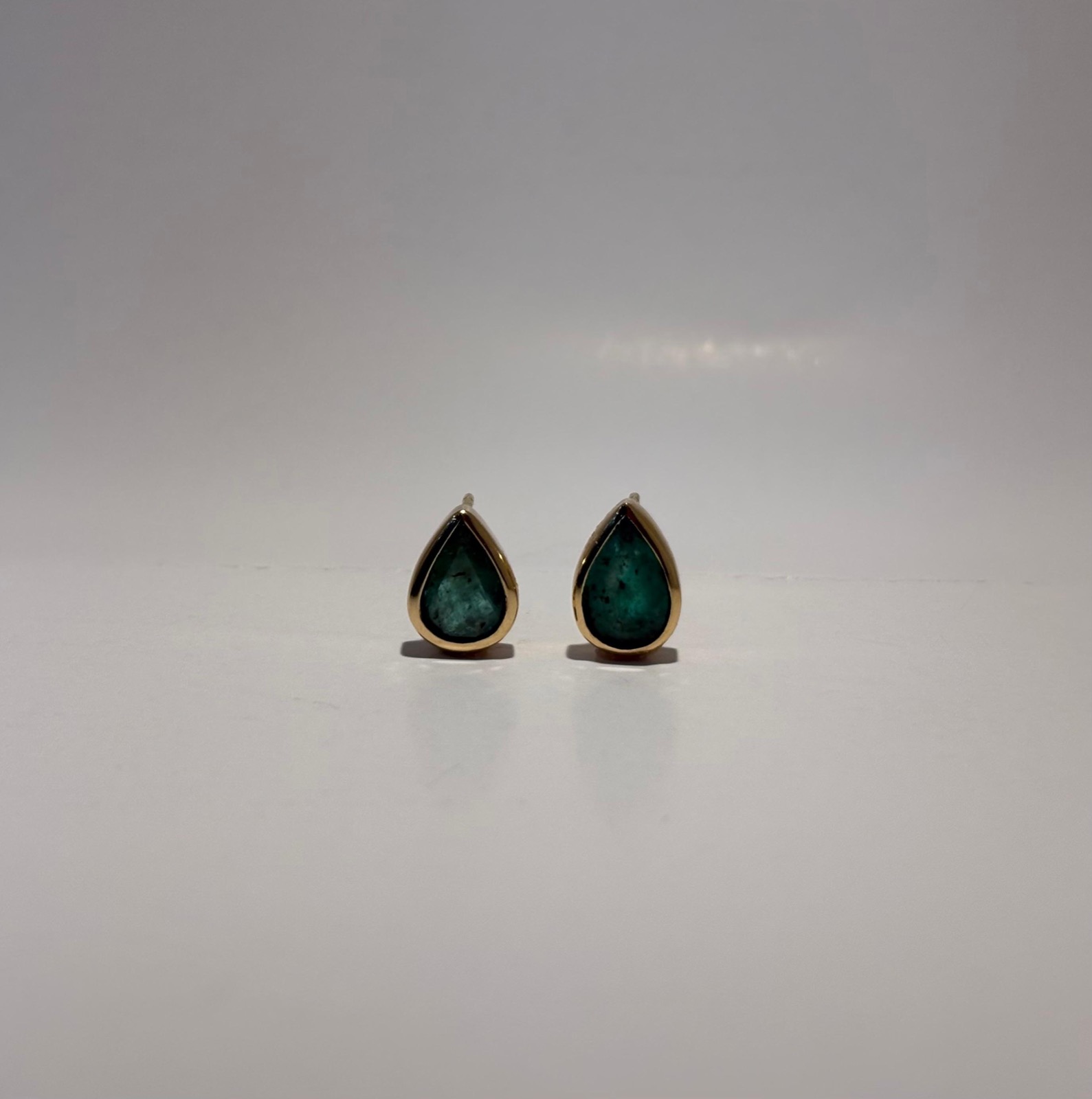 Brincos dourados com pedras verdes